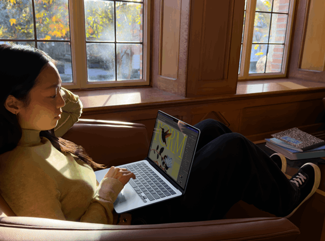 Una persona sentada en una silla usa una MacBook Air