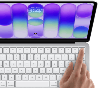 MacBook Neo, color plata, muestra la pantalla de inicio de sesión, el dedo de una persona en el sensor de Touch ID en la esquina superior derecha del teclado