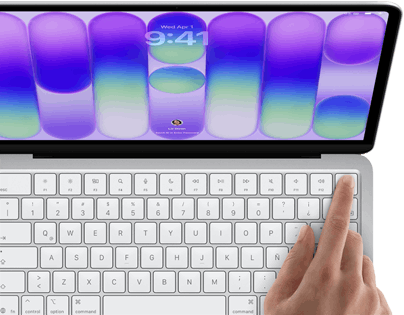 MacBook Neo, color plata, muestra la pantalla de inicio de sesión, el dedo de una persona en el sensor de Touch ID en la esquina superior derecha del teclado