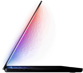 La pantalla de una MacBook Pro entreabierta refleja una luz multicolor sobre el teclado
