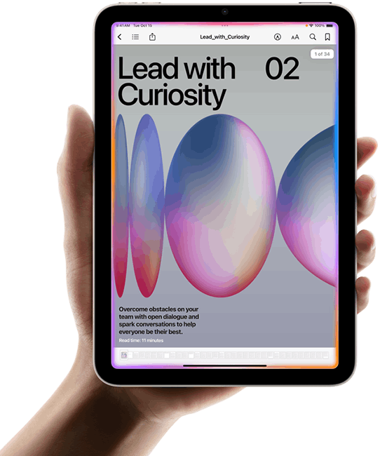 Un usuario sostiene un iPad mini en posición horizontal con una mano. La pantalla muestra la app Libros